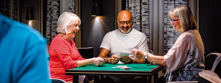 Passengers playing cards in the Card Room on Spirit of Adventure